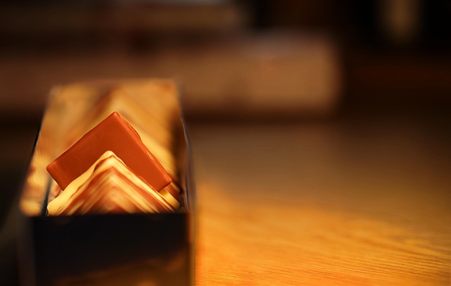 Cosy self-care gift arrangement with candles, bath products, soft blanket, hot chocolate and a good book by a window